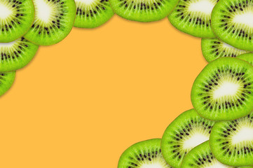 Fototapeta na wymiar Lot of pieces of sliced tasty beautiful ripe fresh kiwi fruit scattered on orange table in kitchen. Top view. Cooking concept. Copy space for your text