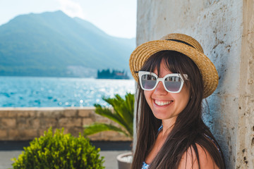 smiling woman portrait in sunglasses. sea with mountains on background