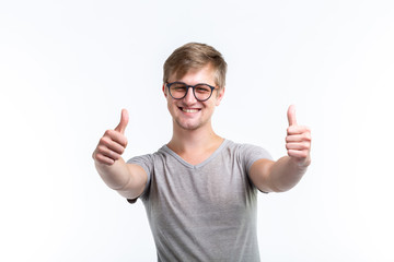 Youth, student and people concept - young man looks like a nerd show us thumbs up over the white...