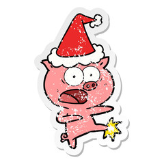 distressed sticker cartoon of a pig shouting and kicking wearing santa hat