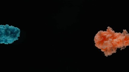 Super slow motion of coloured inks in water. Isolated on black background. Filmed on high speed cinema camera.