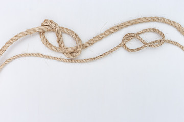 Ship ropes on white wooden background. Double stopper. Copy space.