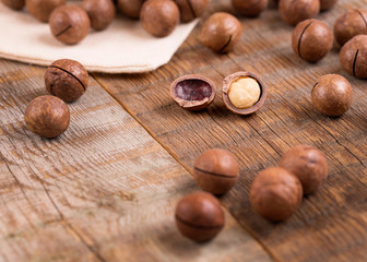Macadamia nuts on a wooden background.
