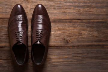 A pair of men shoes close-up on a wooden background.