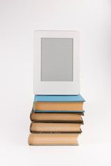 Electronic book on the top of the stack of regular old books isolated on white background