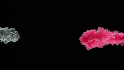 Super slow motion of coloured inks in water. Isolated on black background. Filmed on high speed cinema camera.