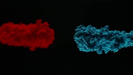 Super slow motion of coloured inks in water. Isolated on black background. Filmed on high speed cinema camera.