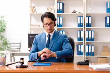 Young handsome judge sitting in courtroom  