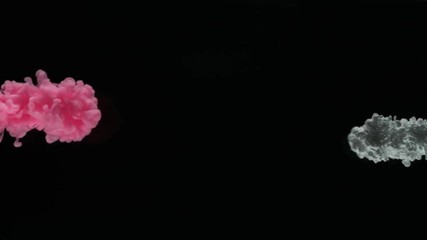 Super slow motion of coloured inks in water. Isolated on black background. Filmed on high speed cinema camera.
