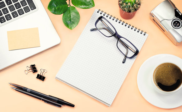 Flat lay, top view, copy space. Office yellow table desk. Workspace with pen, pencil, notebook, computer, glasses, keyboard, and cup of coffee on а beige background - Powered by Adobe