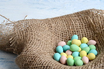 closeup burlap bird nest with easter candy eggs