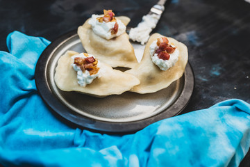Polish cuisine - delicious dumplings with cheese, potatoes, bacon, onion and sour cream