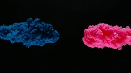 Super slow motion of coloured inks in water. Isolated on black background. Filmed on high speed cinema camera.