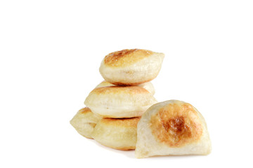 closeup pile of pierogies on white