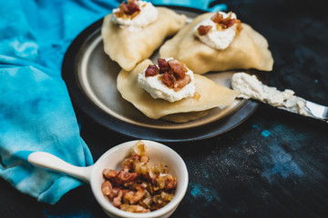 Polish cuisine - delicious dumplings with cheese, potatoes, bacon, onion and sour cream