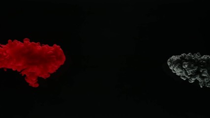 Super slow motion of coloured inks in water. Isolated on black background. Filmed on high speed cinema camera.