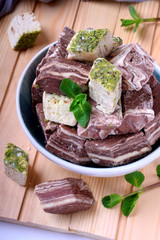 Halva and sherbet in a bowl against the wooden background. Assortment of oriental desserts