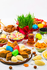 Colored eggs, wheat springs and sweet pastry for Novruz Holiday in Azerbaijan on White Background. Selective focus.