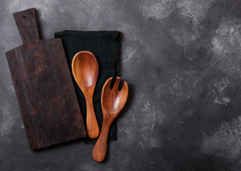 Vintage kitchen wooden utensils with chopping board on stone table background. Top view. Space for text