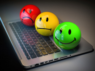 Customer satisfaction h feedback rating concept. Colored smile emoticons on laptop keyboard.