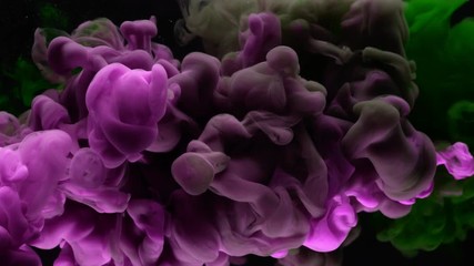 Super slow motion of coloured inks in water. Isolated on black background. Filmed on high speed cinema camera.
