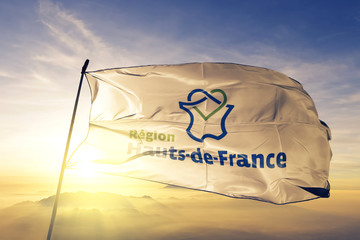 Hauts-de-France of France flag waving on the top sunrise mist fog
