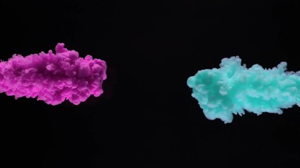 Super slow motion of coloured inks in water. Isolated on black background. Filmed on high speed cinema camera.