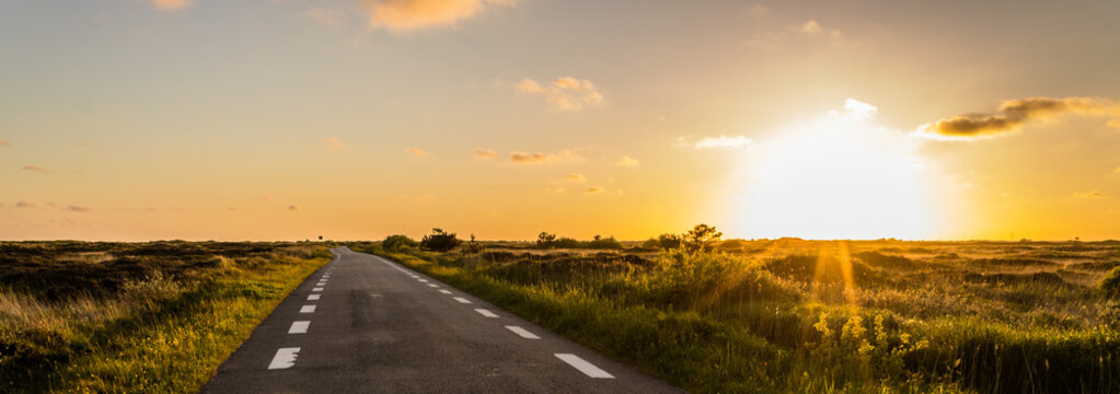 Panoramic View, on a dune landscape in the outback with a plain road to the horizon along the sunset in Denmark on the Island Romo, Tonder, Denmark, Europe