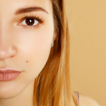 portrait of half face of beautiful woman with beautiful makeup looking at camera