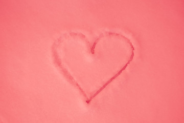 Pink heart painted on pink snow, close-up