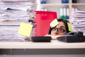 Young female employee in conflicting priorities concept 