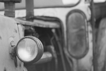 Fototapeta na wymiar Headlight on an old tractor. Monochrome photo