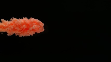 Super slow motion of coloured inks in water. Isolated on black background. Filmed on high speed cinema camera.