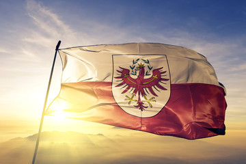 Tirol state of Austria flag waving on the top sunrise mist fog - obrazy, fototapety, plakaty