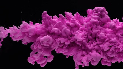 Super slow motion of coloured inks in water. Isolated on black background. Filmed on high speed cinema camera.