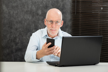 senior businessman reading message to smartphone