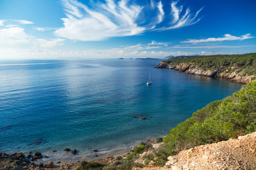Fototapeta na wymiar A quiet bay with a sailing boat on Ibiza island, Spain