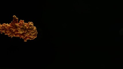 Super slow motion of coloured inks in water. Isolated on black background. Filmed on high speed cinema camera.