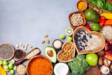 Healthy food background from fruits, vegetables, cereal, nuts and superfood. Dietary and balanced vegetarian eating products on kitchen table top view.