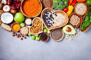 Healthy food background from fruits, vegetables, cereal, nuts and superfood. Dietary and balanced vegetarian eating products on kitchen table top view.