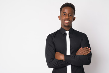 Portrait of happy young African businessman smiling with arms crossed