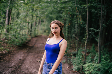 Beautiful girl in short shorts and a blue T-shirt in the woods