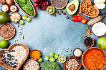 Healthy food background from fruits, vegetables, cereal, nuts and superfood. Dietary and balanced vegetarian eating products on kitchen table top view.