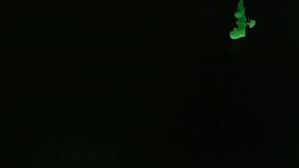 Super slow motion of coloured inks in water. Isolated on black background. Filmed on high speed cinema camera.