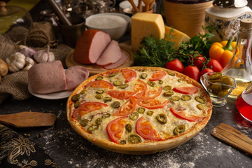 Pizza with ham, tomatoes and jalapeno peppers.