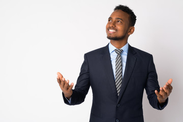 Portrait of happy young African businessman in suit catching something