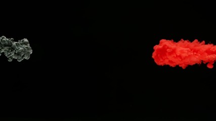 Super slow motion of coloured inks in water. Isolated on black background. Filmed on high speed cinema camera.