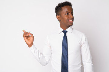 Portrait of happy young African businessman thinking and pointing finger