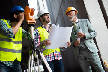 Engineer, foreman and worker discussing in building construction site