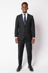 Full body shot of happy young African businessman in suit smiling
